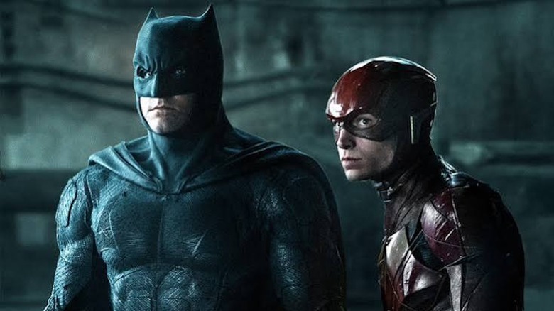 Ben Affleck as Batman stands next to Ezra Miller as The Flash in Justice League