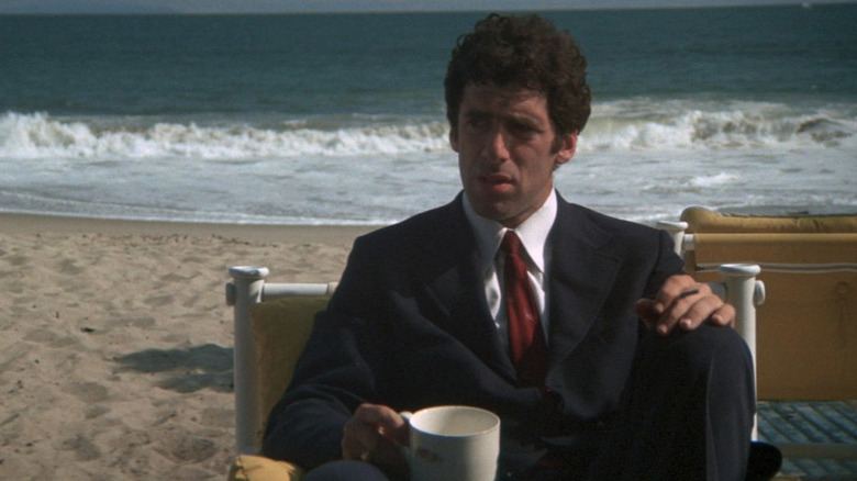 Philip Marlowe (Elliott Gould) drinks coffee on a beach in The Long Goodbye