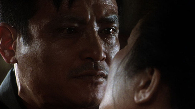 Iwao Enokizu (Ken Ogata) holds a dying woman close in Vengeance Is Mine