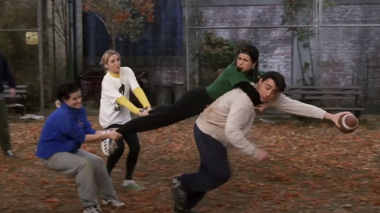 A football-wielding Joey (Matt LeBlanc) is being tackled by Rachel (Jennifer Aniston) while Phoebe (Lisa Kudrow) and Monica (Courteney Cox) try to pull her off him in Friends