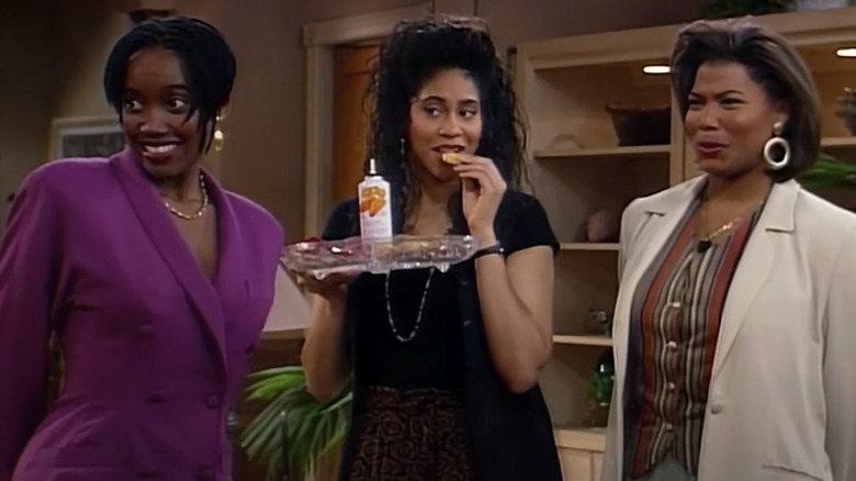 Max Shaw (Erika Alexander), Khadijah James (Queen Latifah), and Regina Hunter look longingly at someone off screen in Living Single
