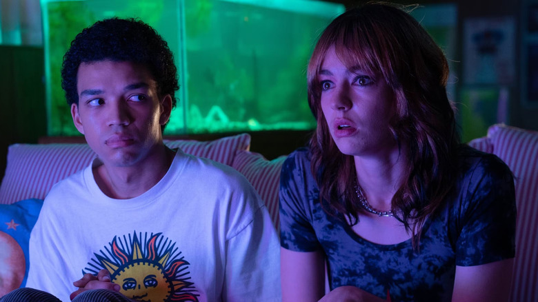 Justice Smith as Owen and Jack Haven as Maddy gazing at a TV with the screen's glow illuminating their faces in I Saw the TV Glow