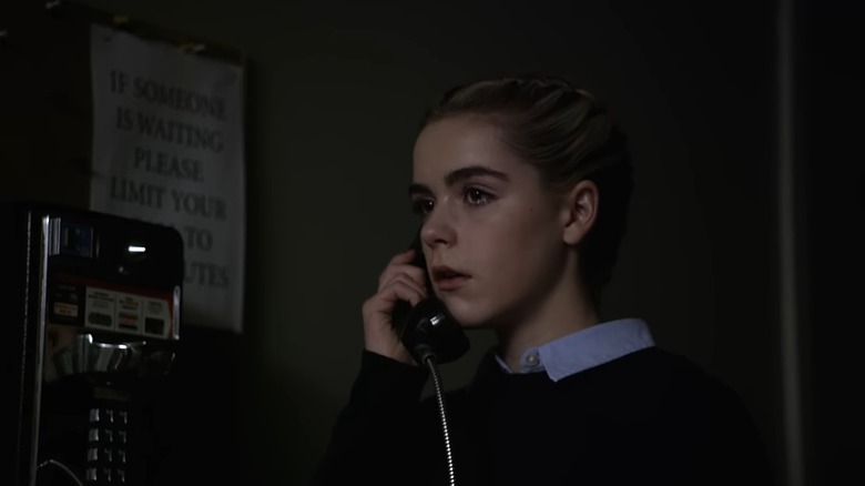 Kiernan Shipka as Kat in The Blackcoat's Daughter, eyes filling with tears as she talks on a payphone