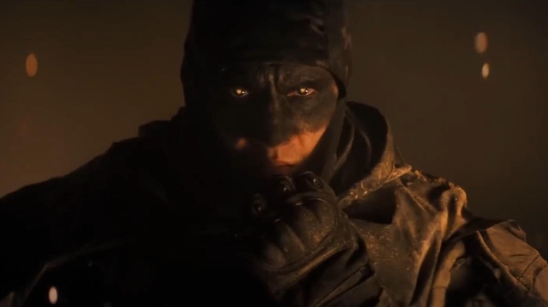 The Butcher pulling up his face mask in Onslaught