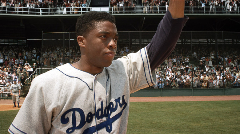 Jackie Robinson (Chadwick Boseman) waves at the audience from the field in 42