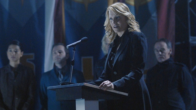 Battlestar Galactica's Number three standing on a pedastal.