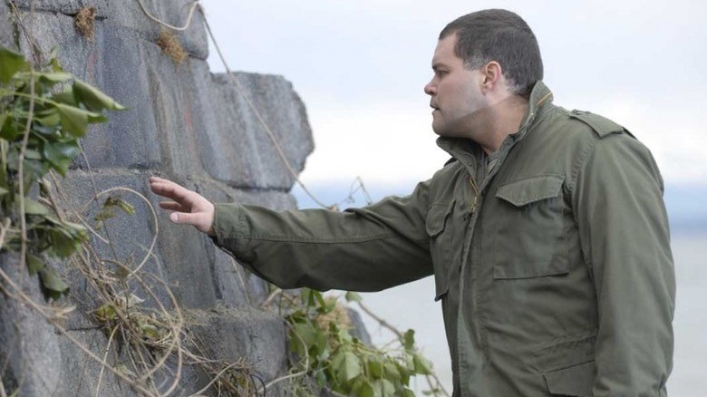 Battlestar Galactica's Chief despondently studies a wall.