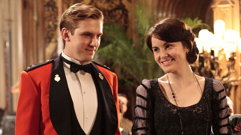 Dan Stevens as Matthew Crawley next to Michelle Dockery as Lady Mary, both in fancy attire in Downton Abbey