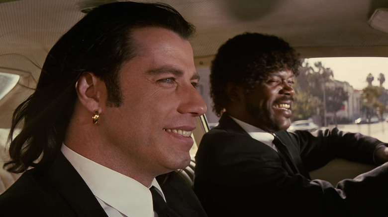 John Travolta as Vincent Vega and Samuel L. Jackson as Jules Winnfield in Pulp Fiction, riding in a car together and smiling.
