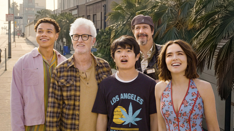 Gail Daughtry (Zoey Deutch) stands on Sunset Blvd with Otto (Miles Gutierrez-Riley), John Slattery, Caleb, (Ben Wang), and Vincent (Ken Marino), all looking eager in Gail Daughtry and the Celebrity Sex Pass