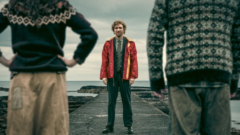 Daniel (Domhnall Gleeson) stands in front of Isla (Gayle Rankin) and Sandy (Grant O'Rourke) on an island in The Incomer