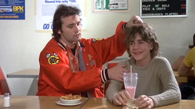 Tripper Harrison (Bill Murray) holds up Rudy Gerner (Chris Makepeace) by his hair in Meatballs