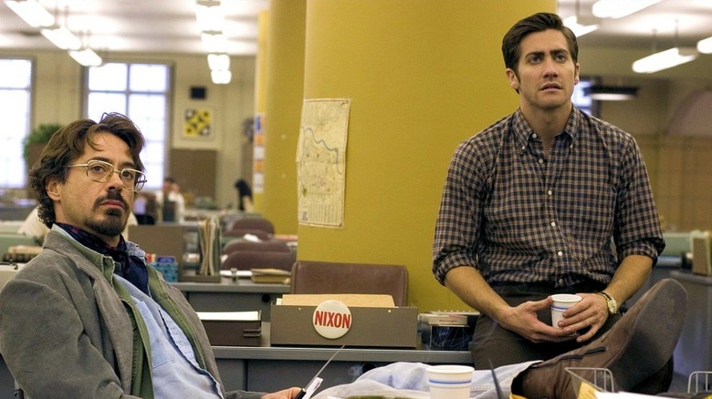 Paul Avery (Robert Downey, Jr.) and Robert Graysmith (Jake Gyllenhaal) sit together in the newsroom in Zodiac