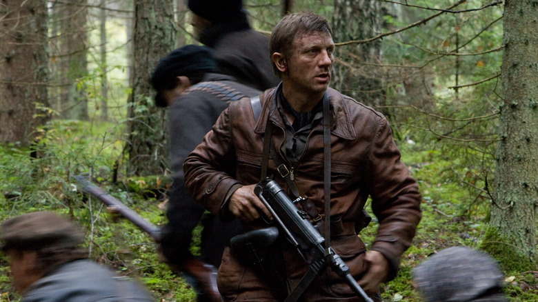 Daniel Craig in Defiance holding a gun in forest