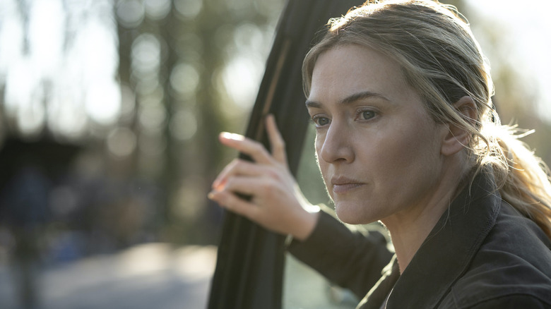 Mare Sheehan (Kate Winslet) exits her car during sunset in Mare of Easttown