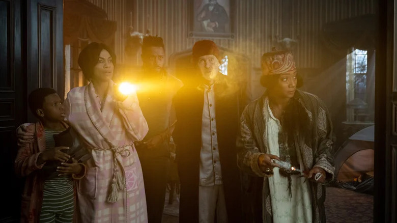 Chase W. Dillon, Rosario Dawson, LaKeith Stanfield,Owen Wilson, and Tiffany Haddish in pajamas exploring a haunted house in Haunted Mansion