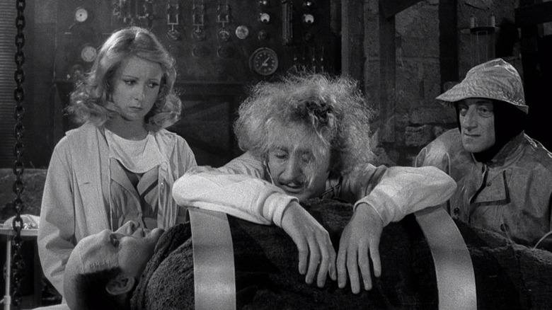 Victor Frankenstein (Gene Wilder) slouches over the body of the monster (Peter Boyle) in Young Frankenstein