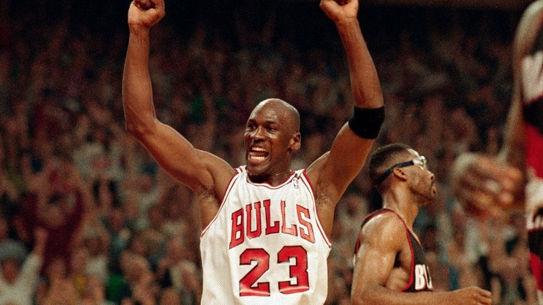 Michael Jordan raises his hands and cheers in a Bulls game featured in The Last Dance.