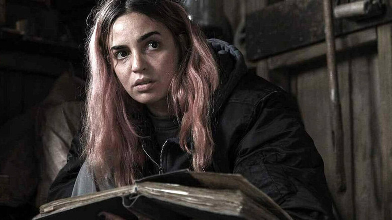 Souheila Yacoub as Alice studies the Necronomicon in Evil Dead Burn