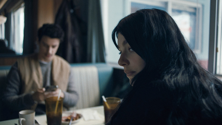Rachel (Camila Morrone) looks over her shoulder uneasily in Something Very Bad is Going to Happen