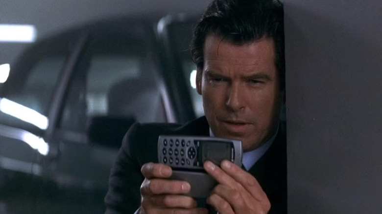 Pierce Brosnan as James Bond plays with his cell phone in Tomorrow Never Dies