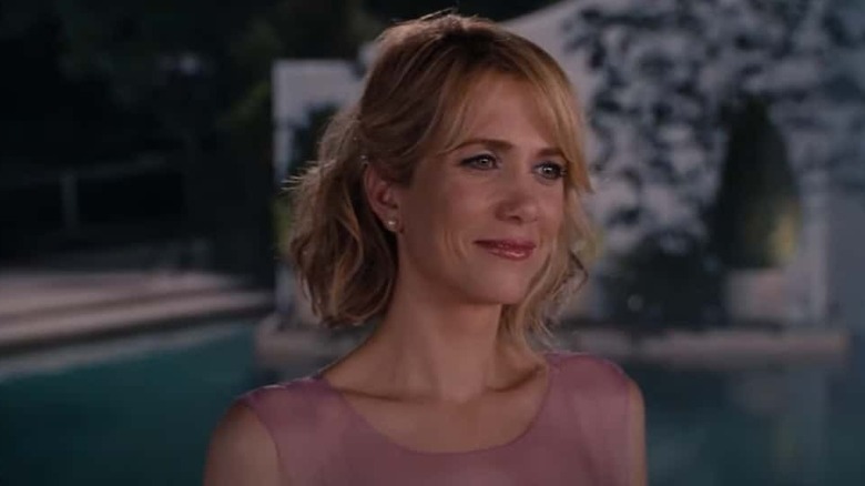 Kristen Wiig smiling in pink dress in Bridesmaids