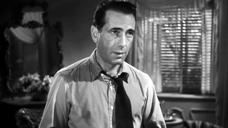 A sweaty Philip Marlowe (Humphrey Bogart) stands sternly in The Big Sleep