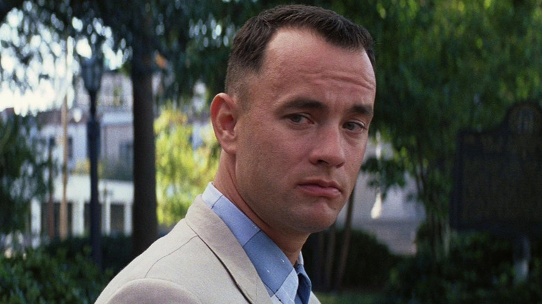 Forrest Gump (Tom Hanks) looks to his right in a park in Forrest Gump