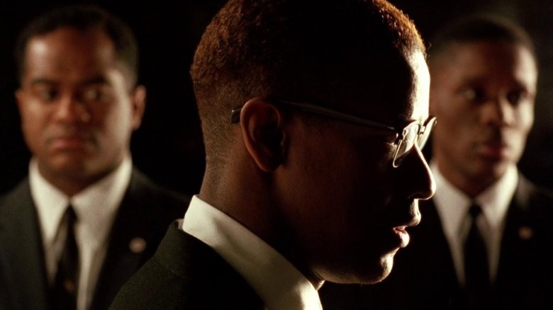 Malcolm X (Denzel Washington) points a gun to his head in Malcolm X