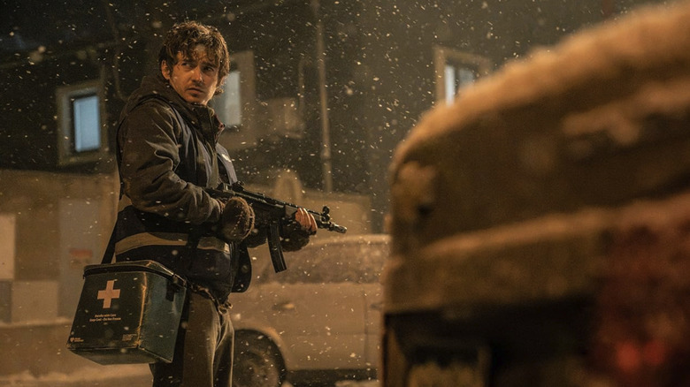 Bryan standing with a gun outside in the snow in Resident Evil