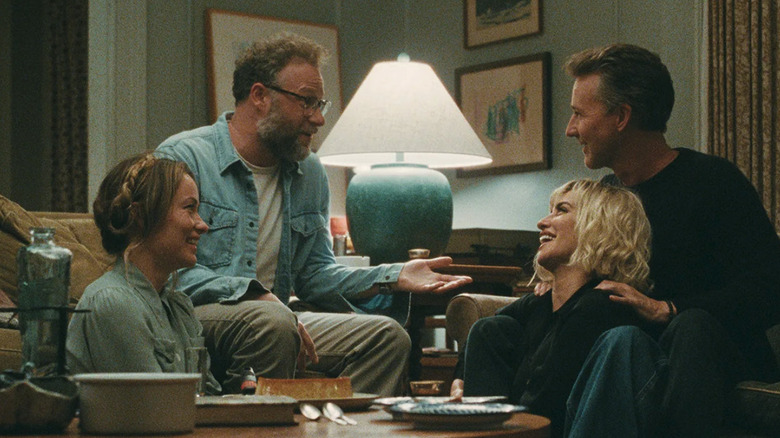 Angela (Olivia Wilde), Joe (Seth Rogen), Hawk (Edward Norton), and Pina (Penélope Cruz) converse in the living room in The Invite