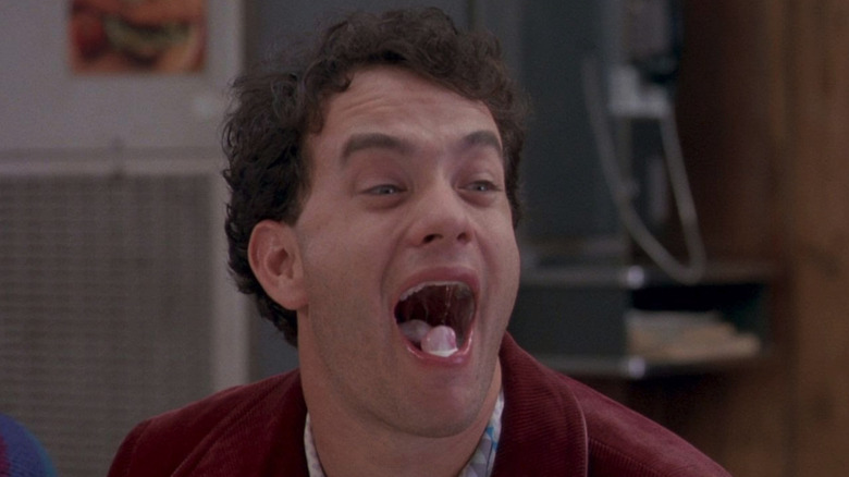 Tom Hanks as Joshua Baskin, gleefully showing off a cherry and ice cream in his mouth in Big.