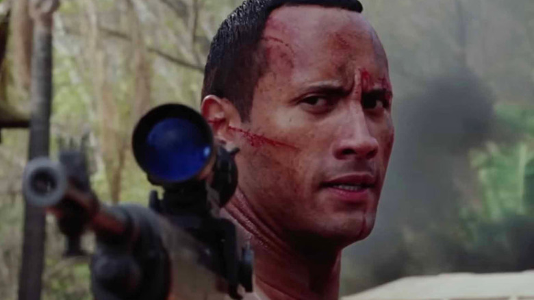 Dwayne Johnson as Beck, holding a gun in The Rundown