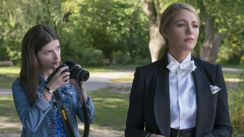 Anna Kendrick as Stephanie holding camera next to Blake Lively in suit as Emily in A Simple Favor