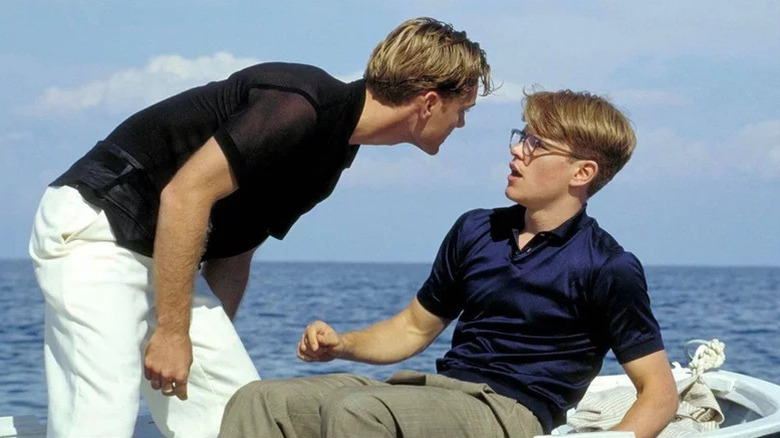 Jude Law as Dickie leaning over and yelling at seated Matt Damon as Ripley in The Talented Mr. Ripley