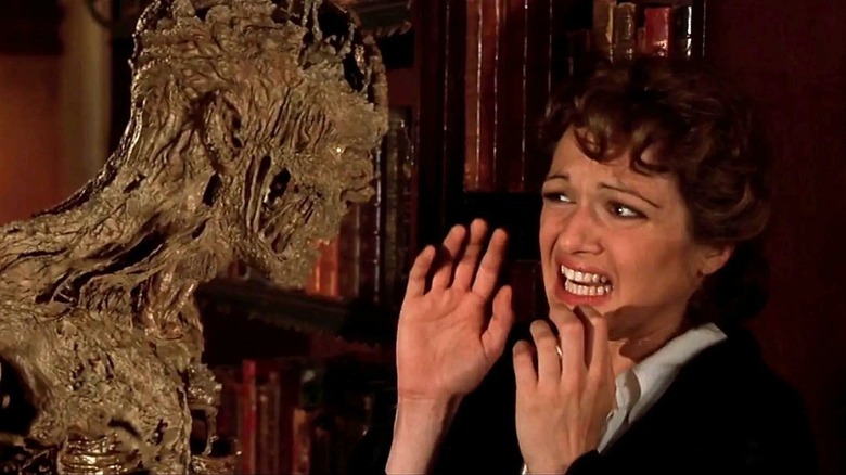 Rachel Weisz as Evelyn screams while standing across from a skinless mummy in The Mummy