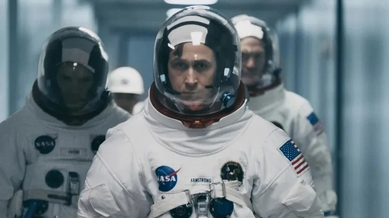 Neil Armstrong (Ryan Gosling) walks down a corridor in his spacesuit in First Man