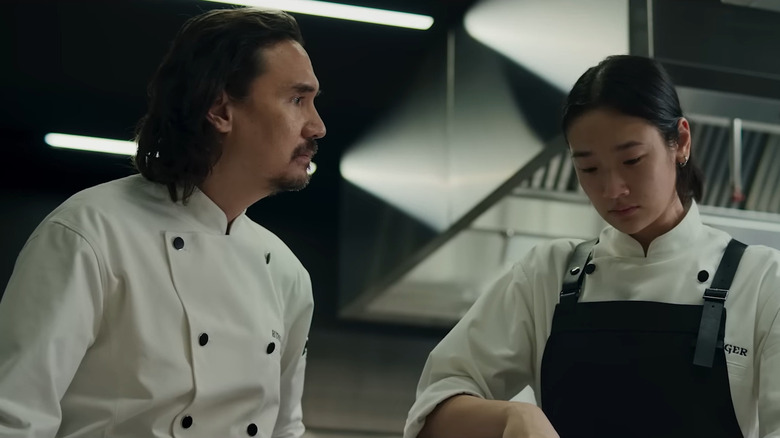 Nopachai Jayanama as Chef Paul standing next to Chutimon Chuengcharoensukying as Aoy in commercial kitchen in The Hunger