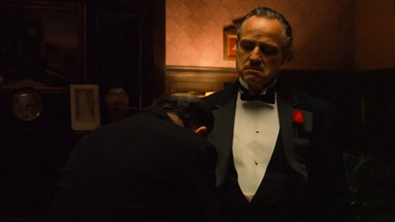 Marlon Brando as Don Corleone listens to another man in The Godfather