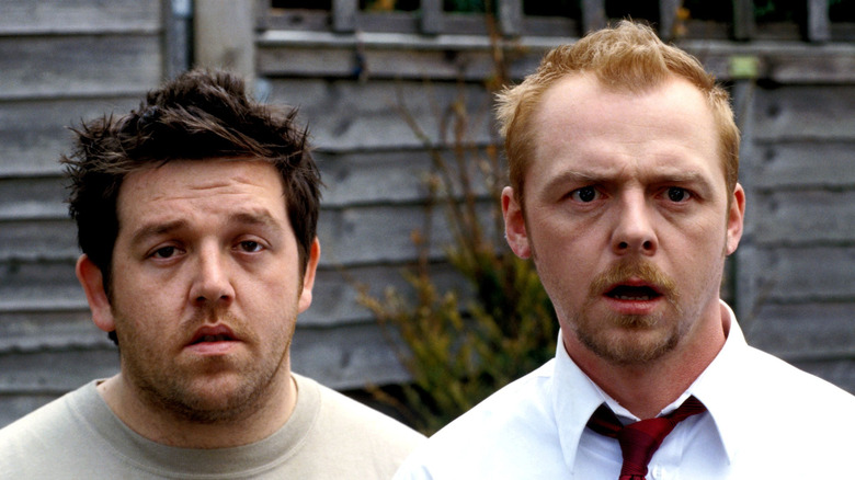 Ed (Nick Frost) and Shaun (Simon Pegg) face each other incredulously in front of two zombies in Shaun of the Dead