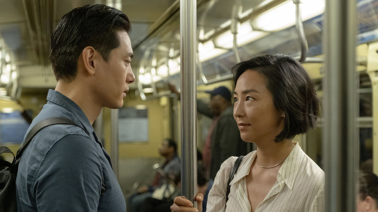 Teo Yoo as Hae sung and Greta Lee as Nora, look at each other on a subway in Past Lives
