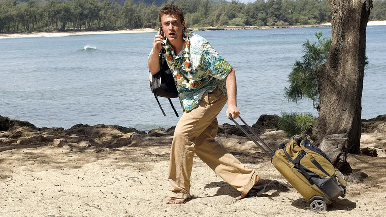 Jason Segel as Peter Bretter dragging a rolling suitcase along the beach while on his mobile phone in Forgetting Sarah Marshall.