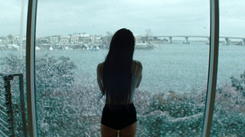 Mikey Madison as Ani staring out a window at Brooklyn in Anora