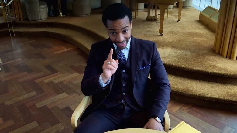Ray Burke in an office, raising a finger in High-Flying Bird
