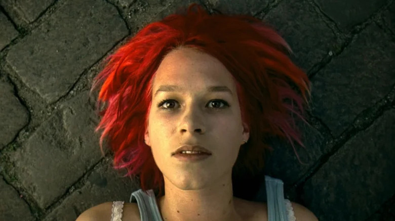 Lola (Franka Potente) stares glassy-eyed up from laying on a sidewalk in Run Lola Run