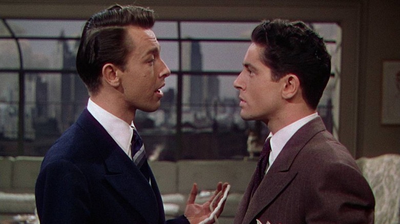 John Dall as Brandon holding a rope standing in front of Farley Granger as Phillip in Rope