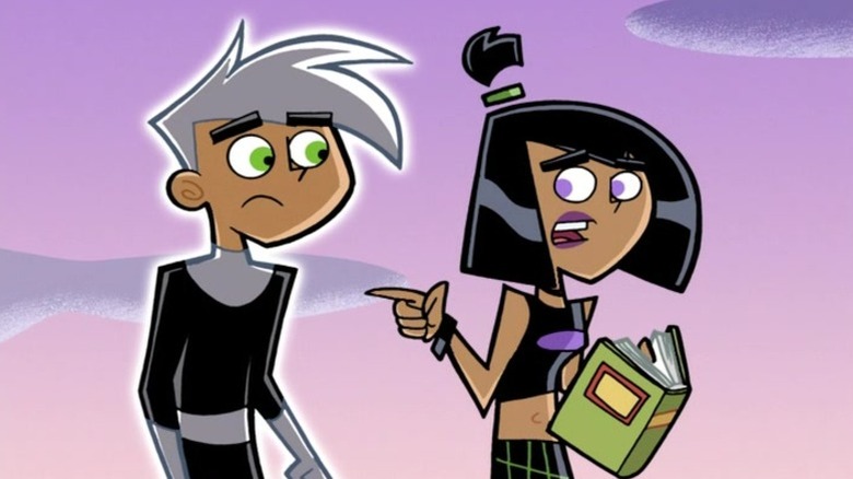 Sam pointing to Danny while speaking and holding a book on Danny Phantom