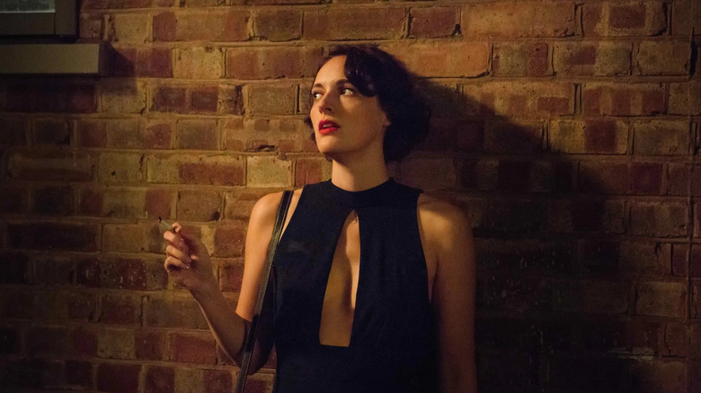 Phoebe Waller-Bridge as Fleabag, leaning against a wall and smoking a cigarette, in Fleabag.