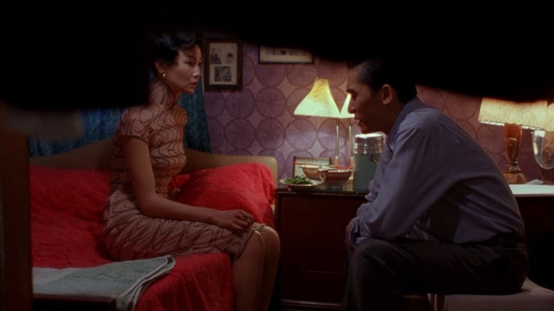 Maggie Cheung as Su Li-zhen and Tony Leung Chiu-wai as Chow Mo-wan sitting in a bedroom and talking in In the Mood for Love