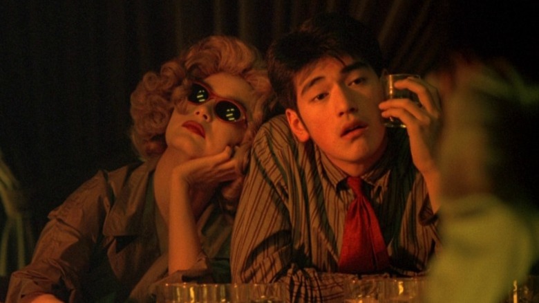 Brigitte Lin as the woman in the blond wig and Takeshi Kaneshiro as He Zhiwu drinking in Chungking Express